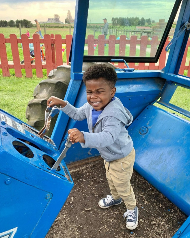 toddler boy playing at farm - with crane